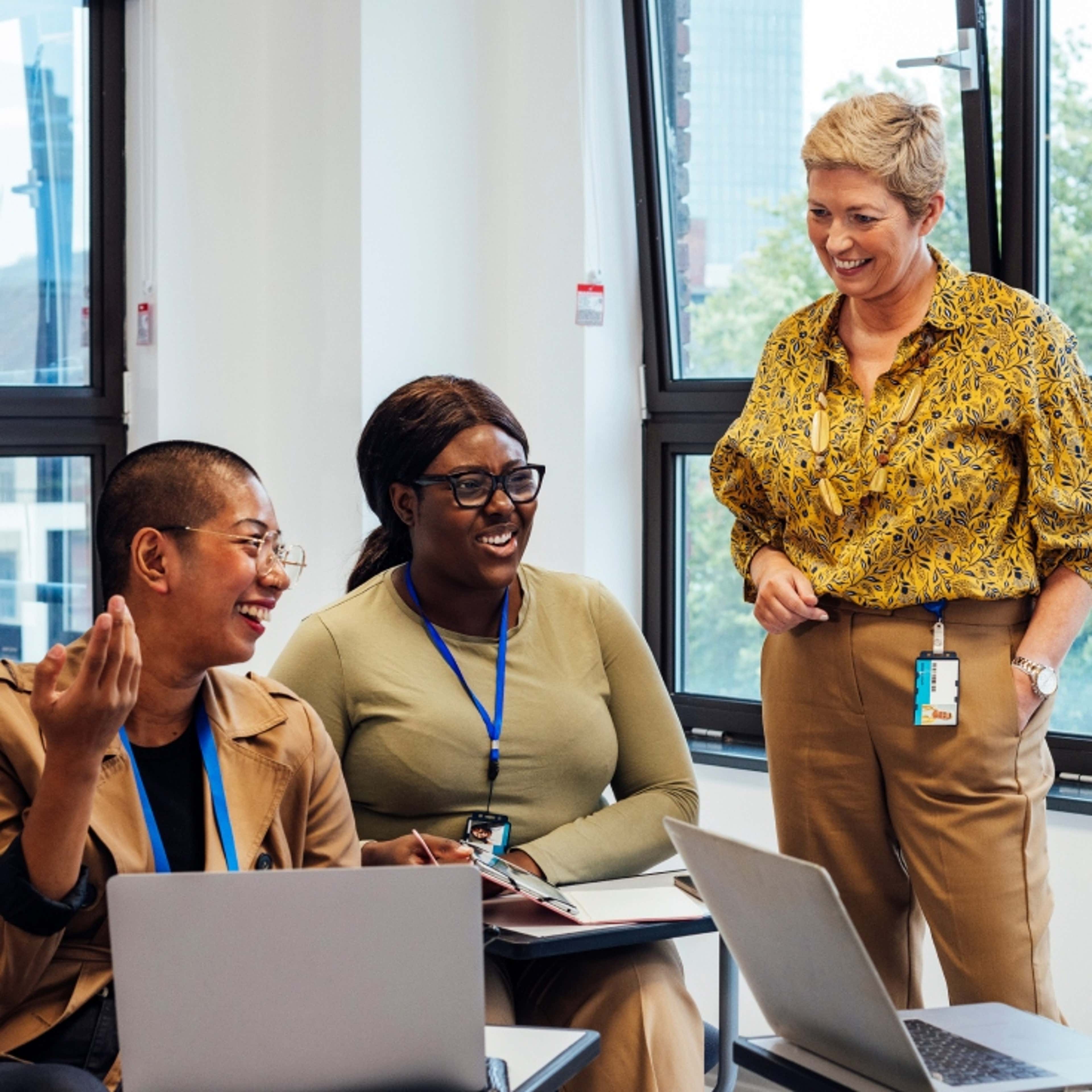 Person with glasses sitting looking at camera and smiling