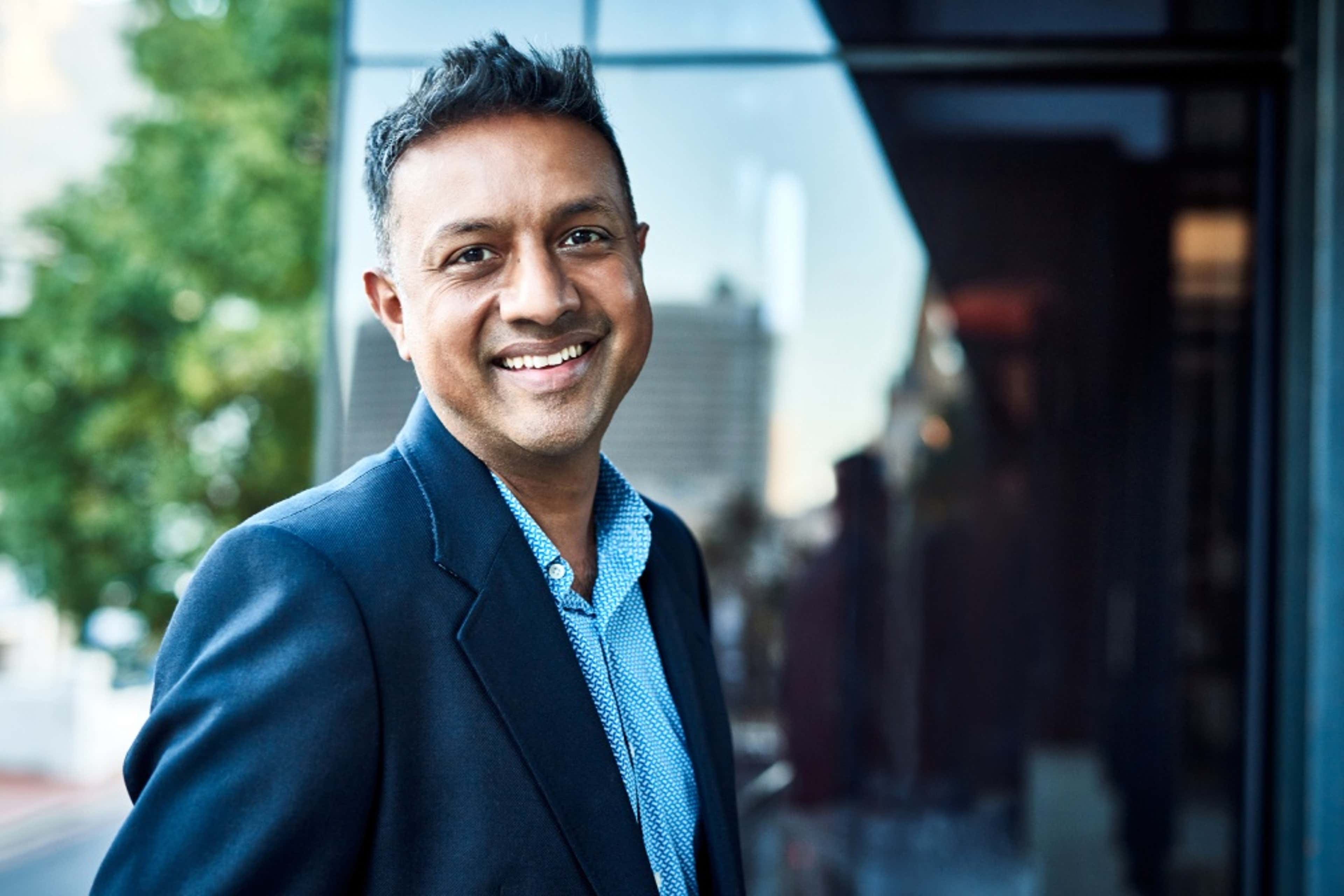 Person with glasses standing and smiling