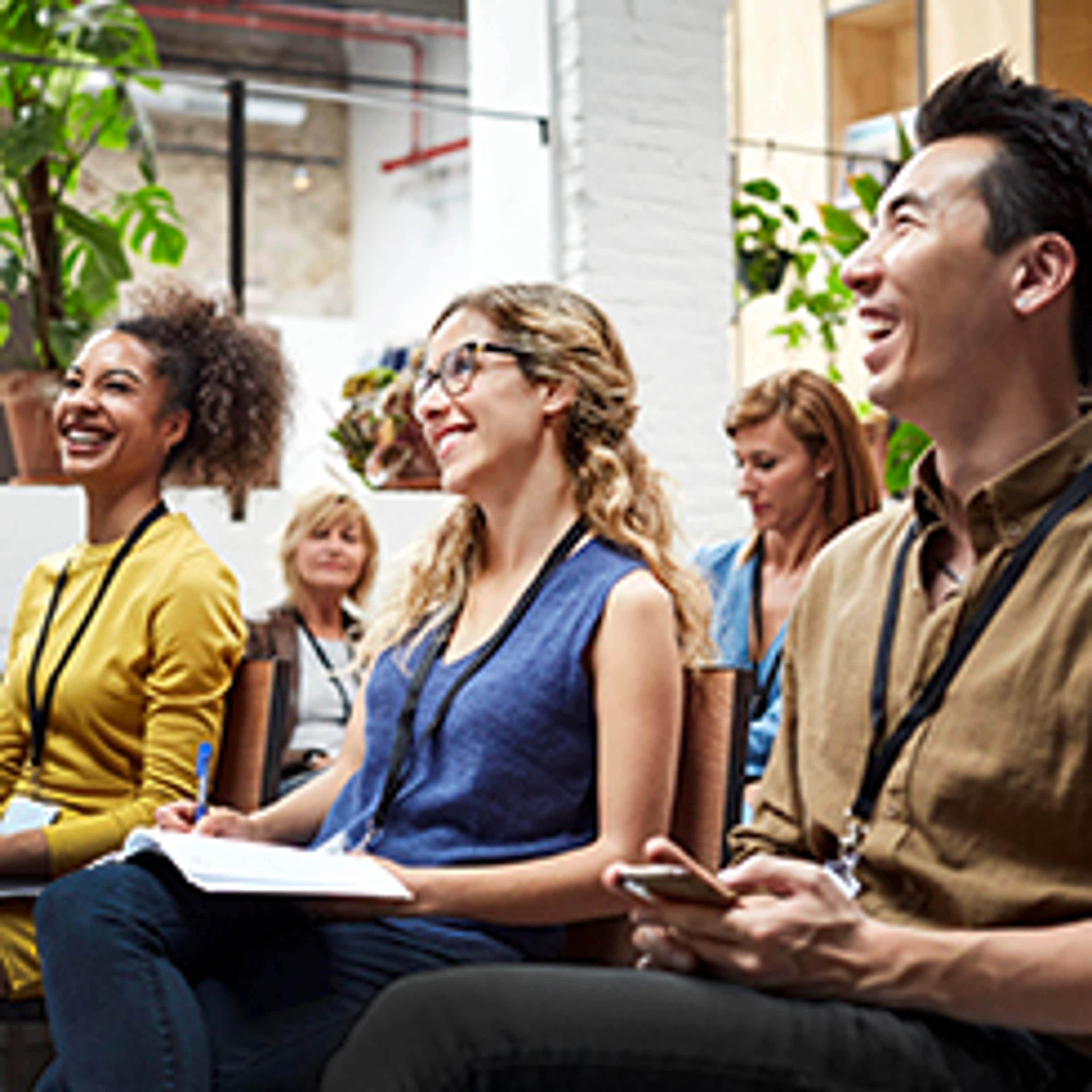 People sitting looking at front of room and laughing