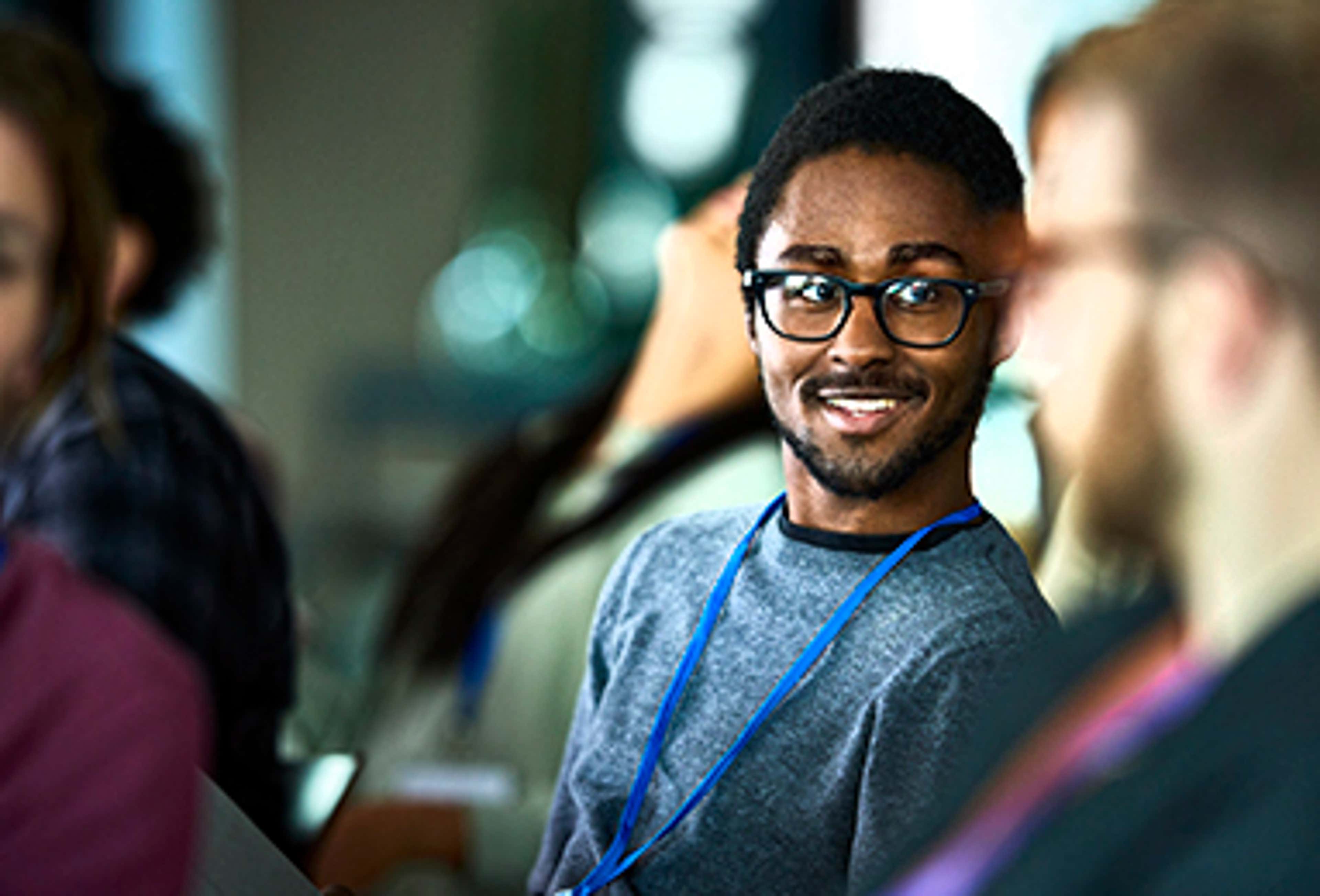 Student sitting, smiling and looking at someone
