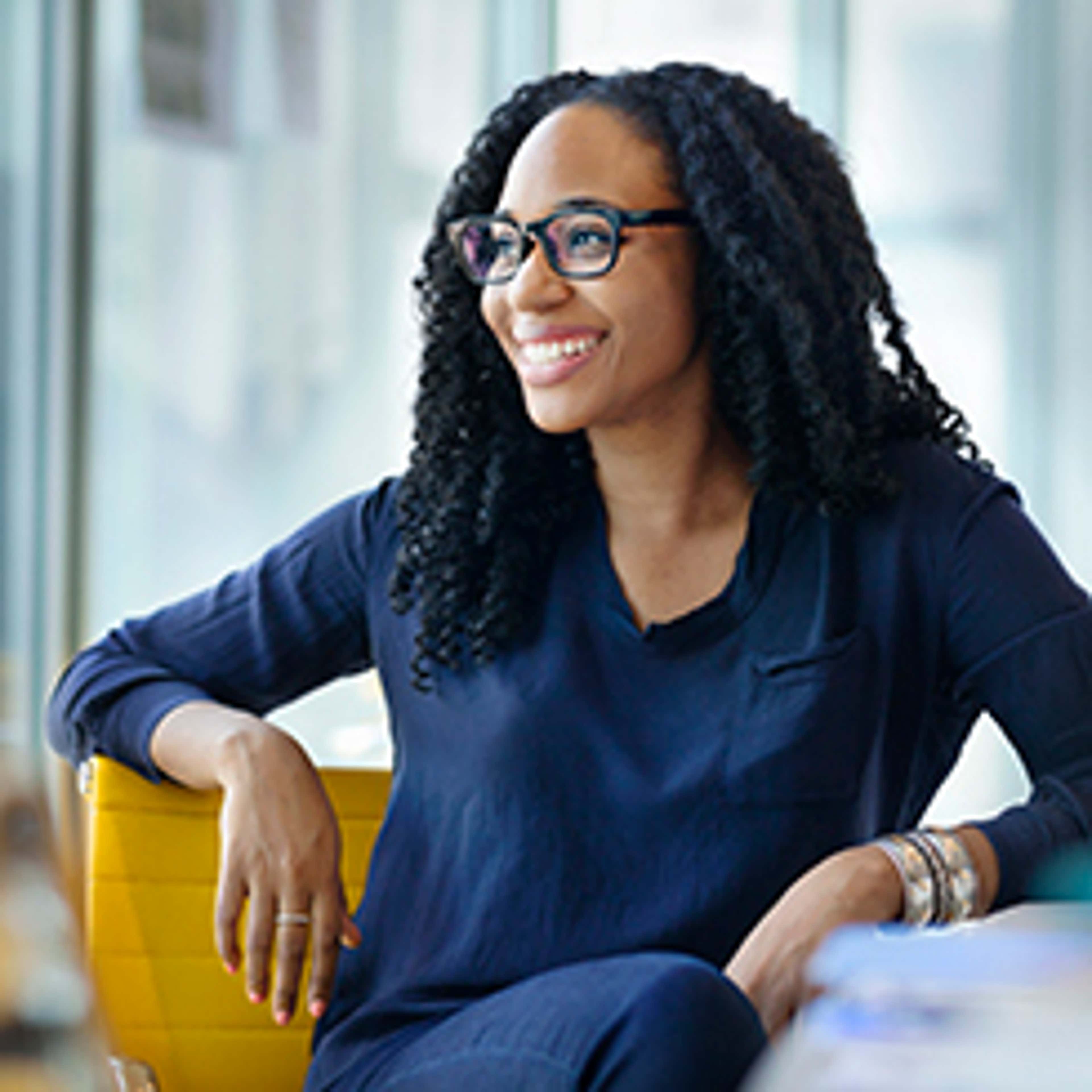 Person sitting in yellow chair smiling