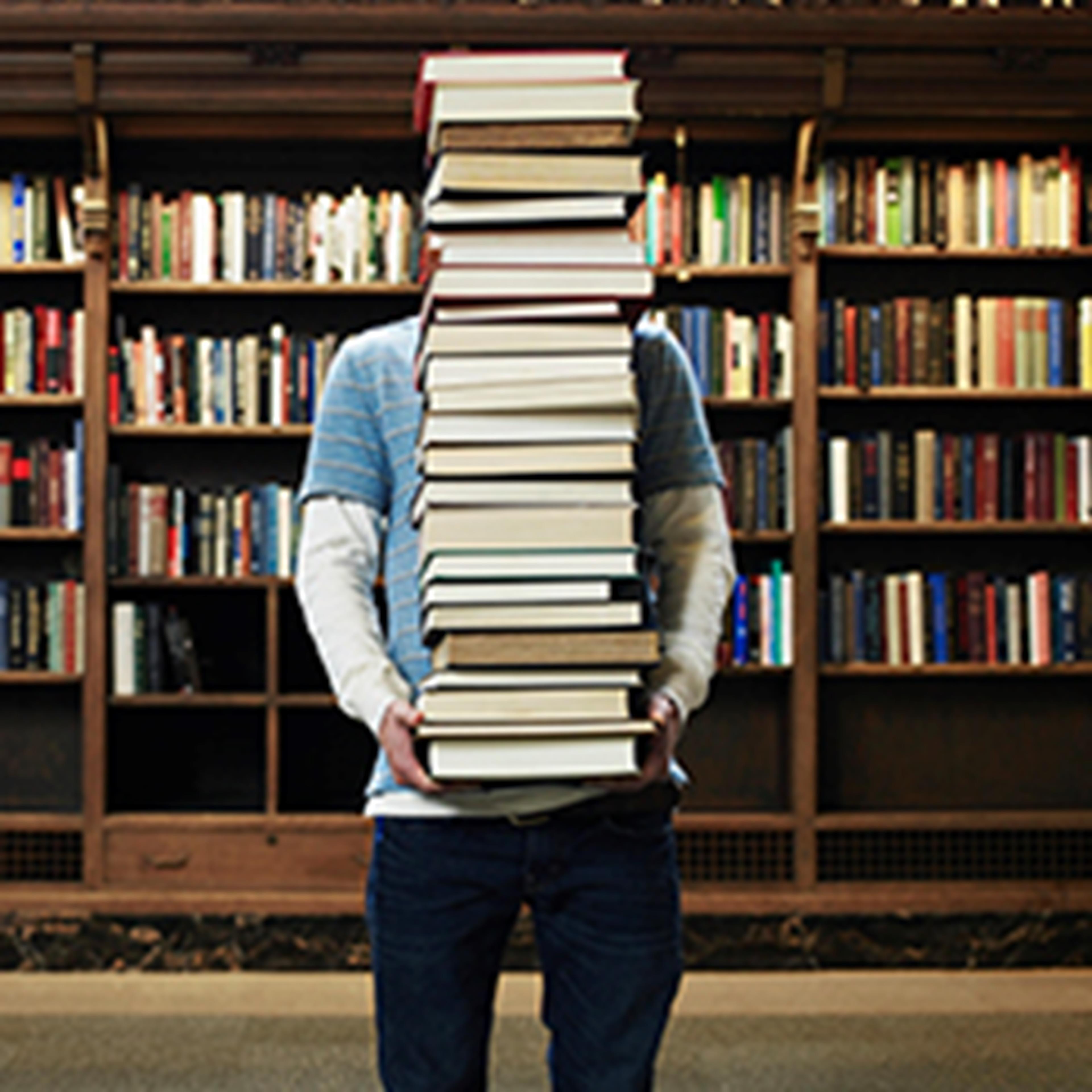 Person holding a lot of books piled in their arms in a library