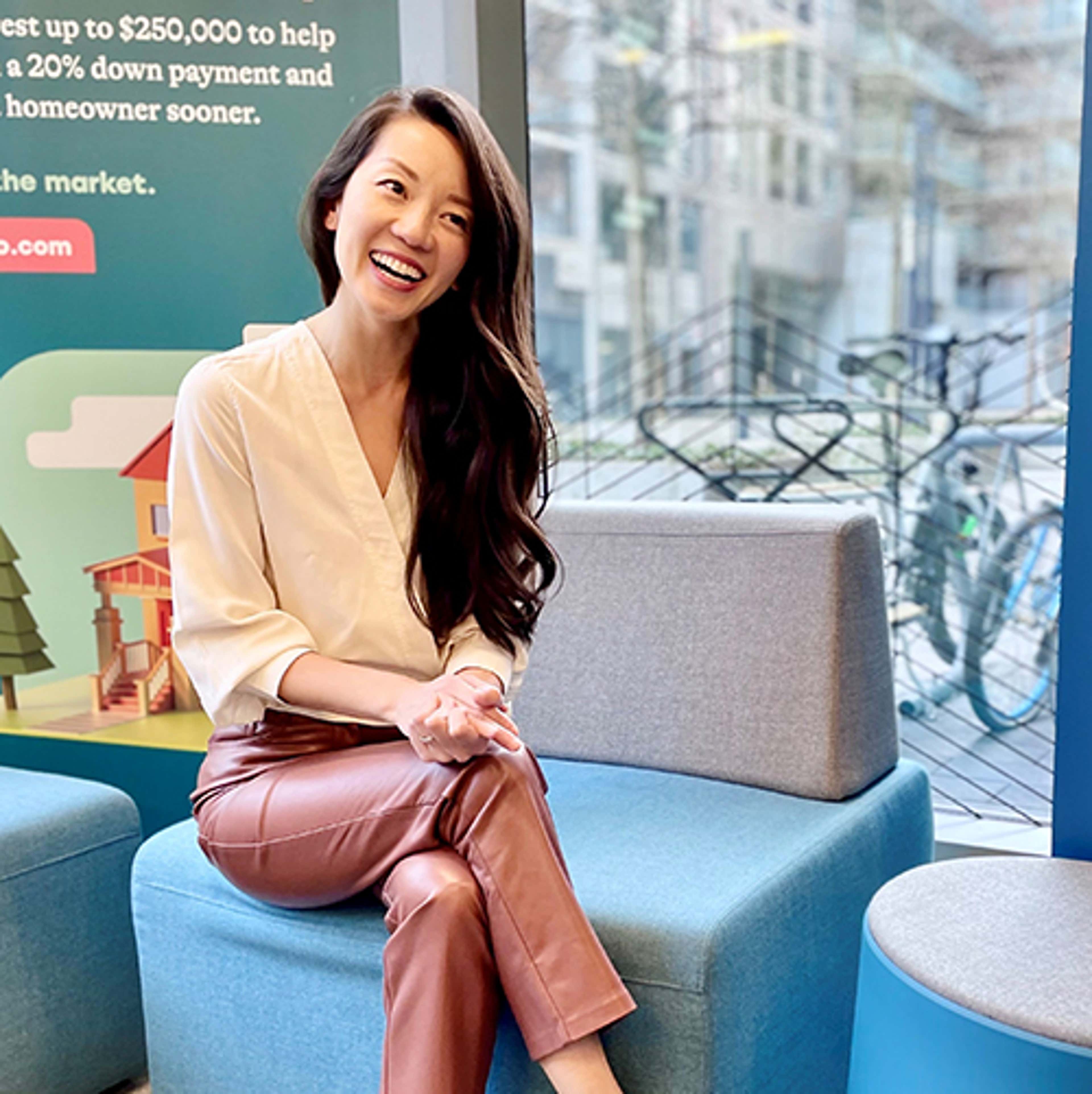 Alex sitting on a chair, smiling