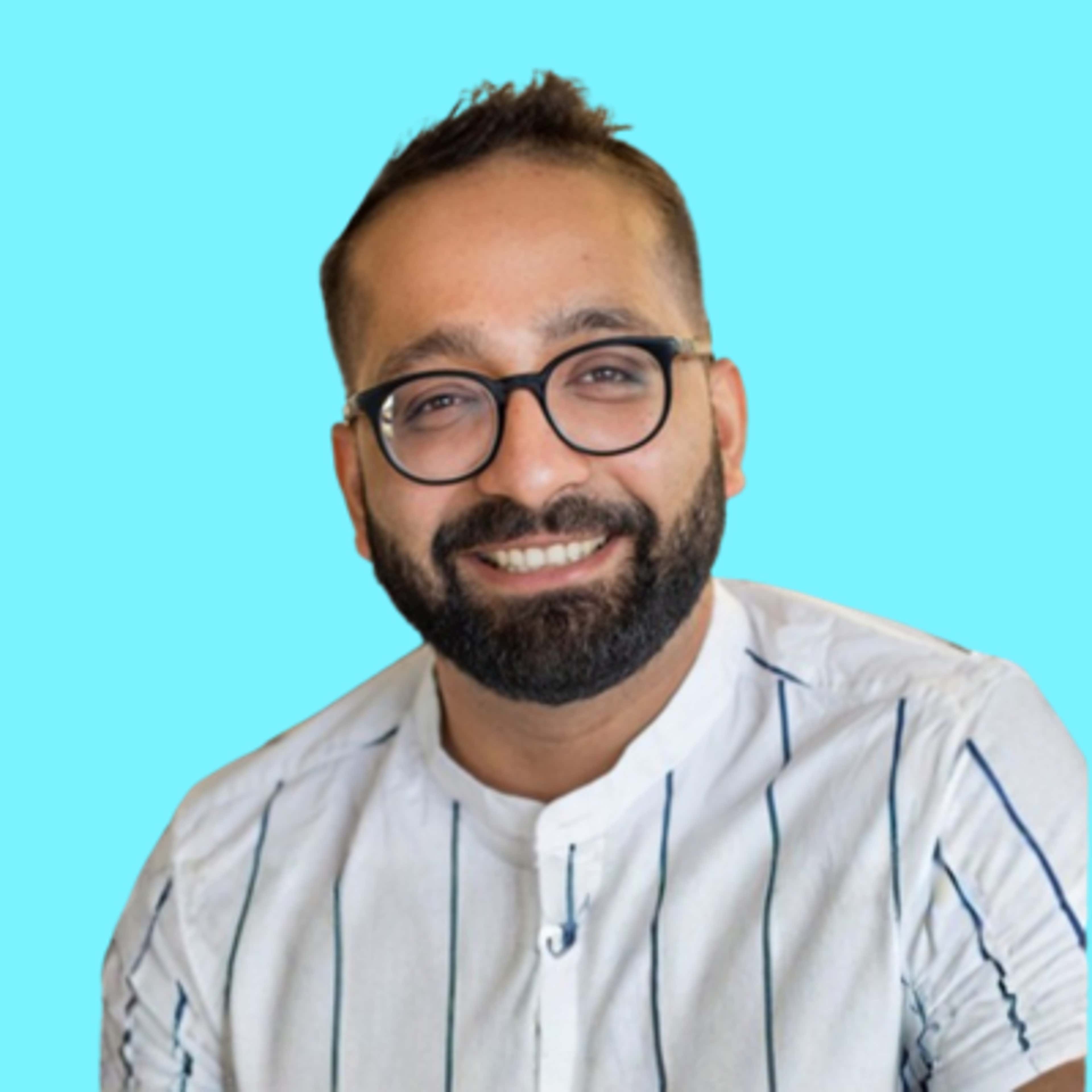 A smiling man with glasses and a beard