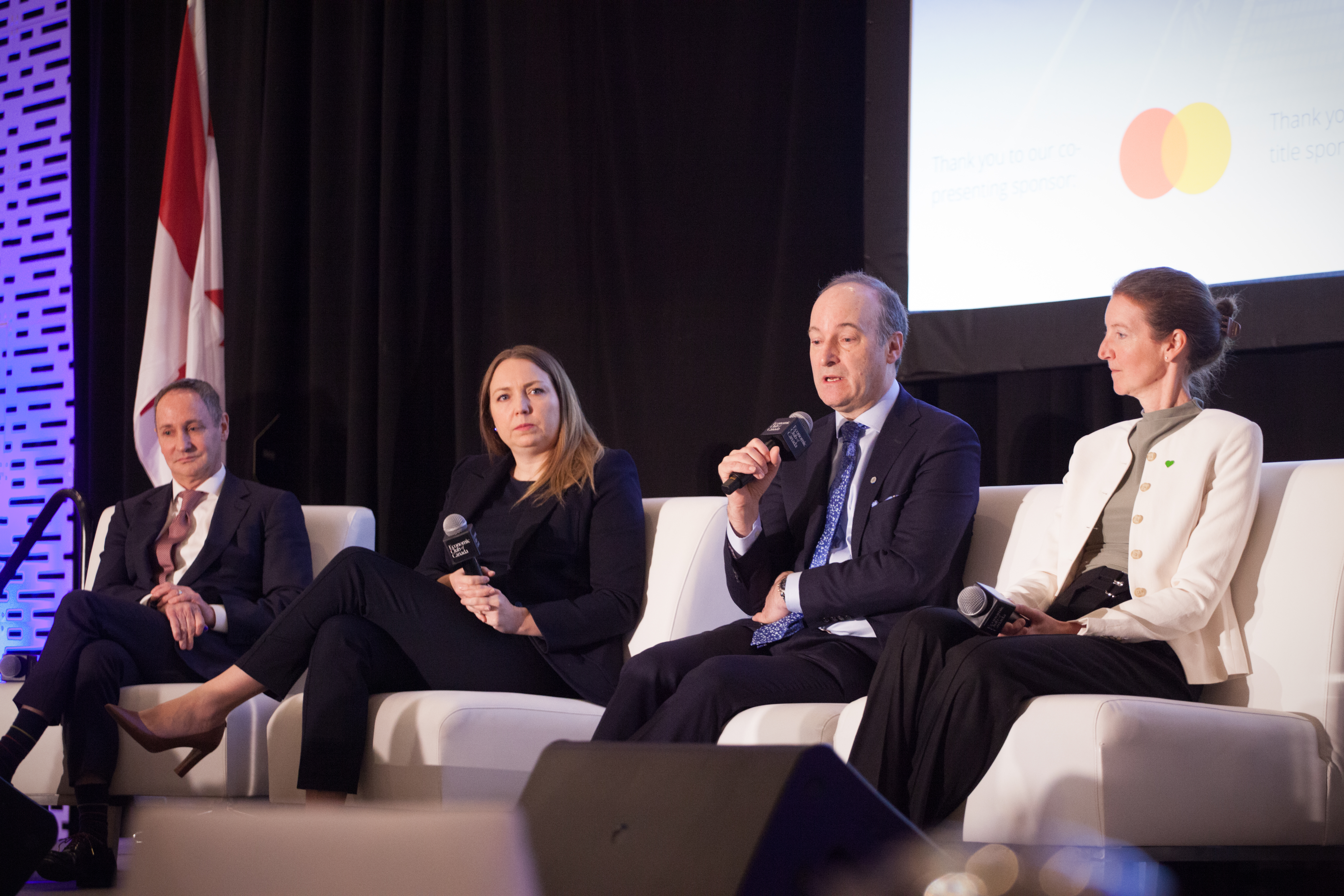 Panelists speaking on stage