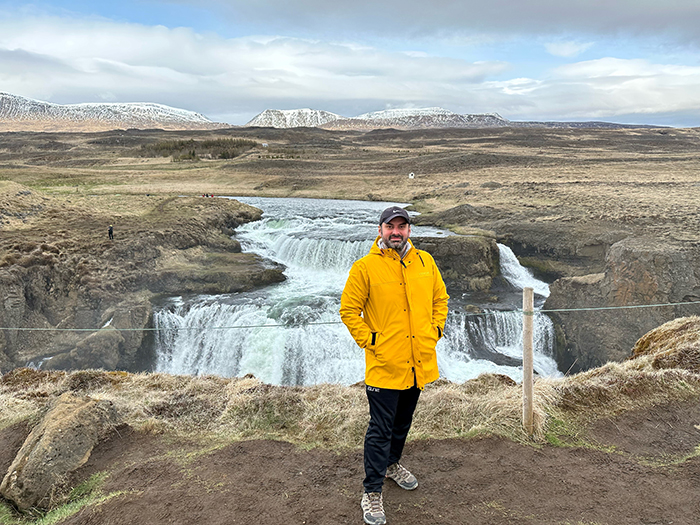 Elie standing in front of a waterfall
