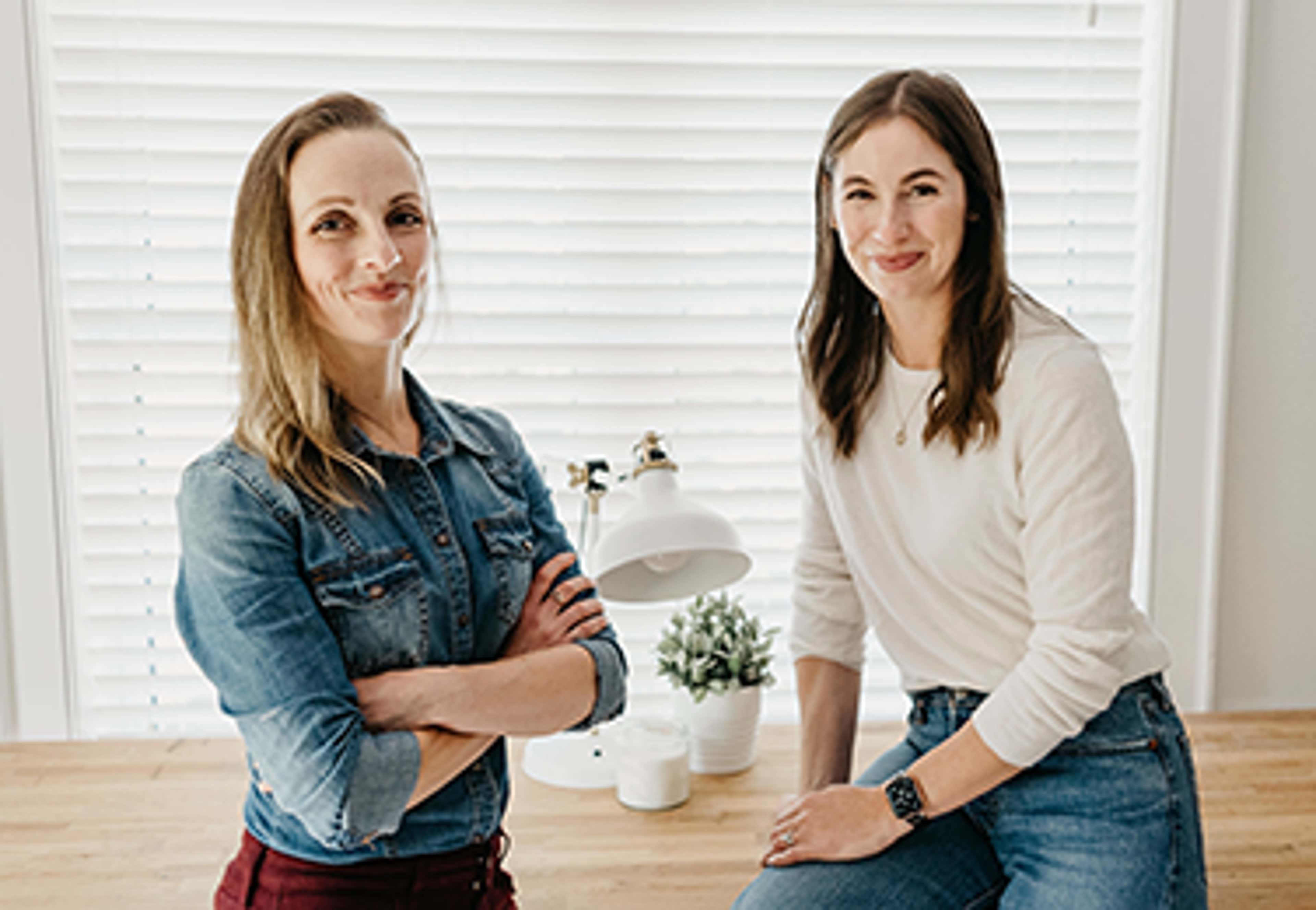 Grow CPA owners standing in front of a window smiling at camera
