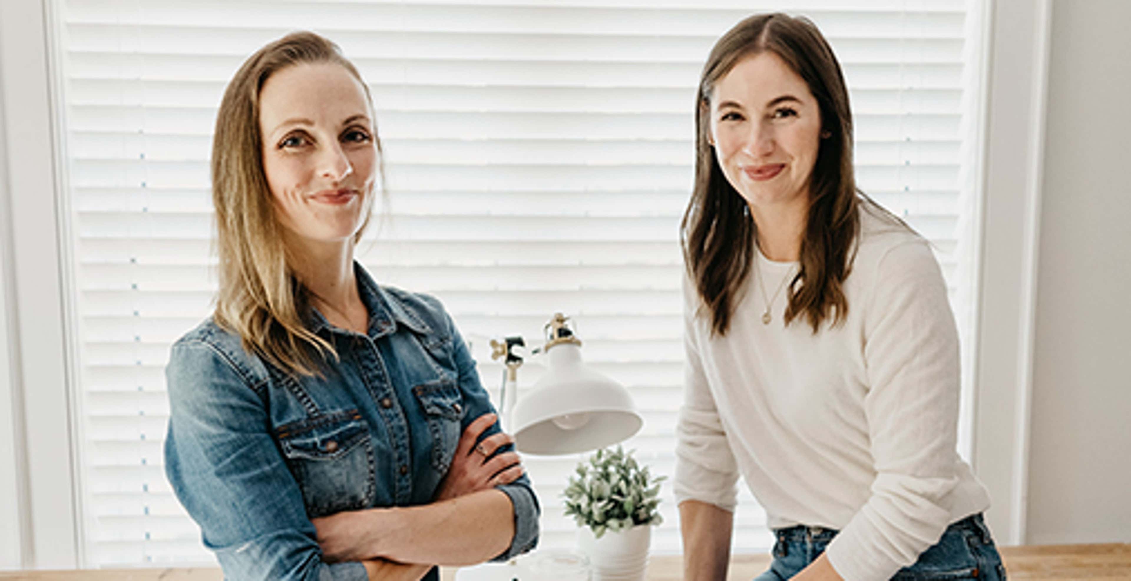 Grow CPA owners standing in front of a window smiling at camera