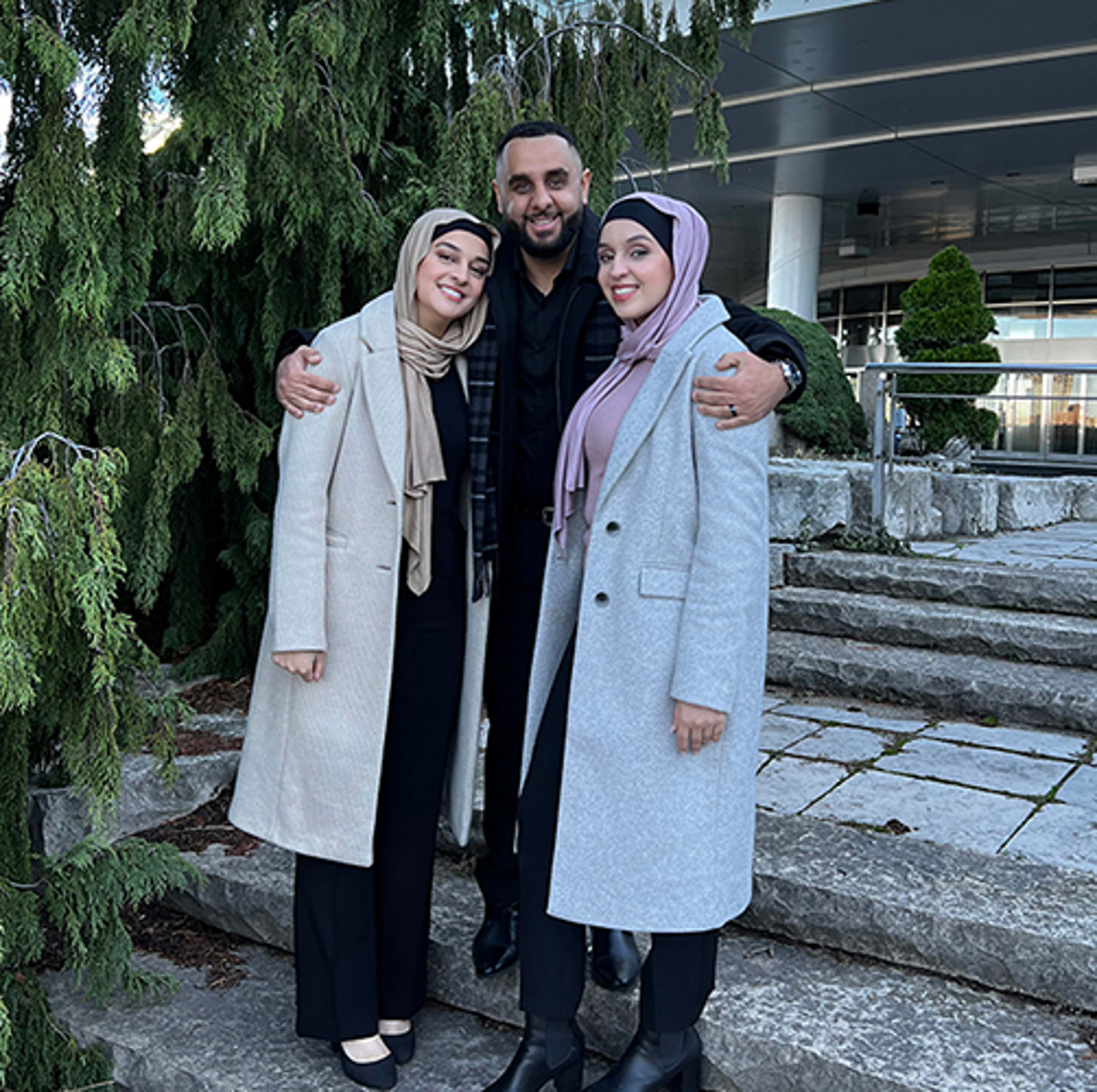 The Hedjazi siblings, Sarah, Sammer and Summer standing together in front of a building