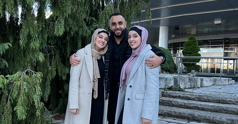 The Hedjazi siblings, Sarah, Sammer and Summer standing together in front of a building