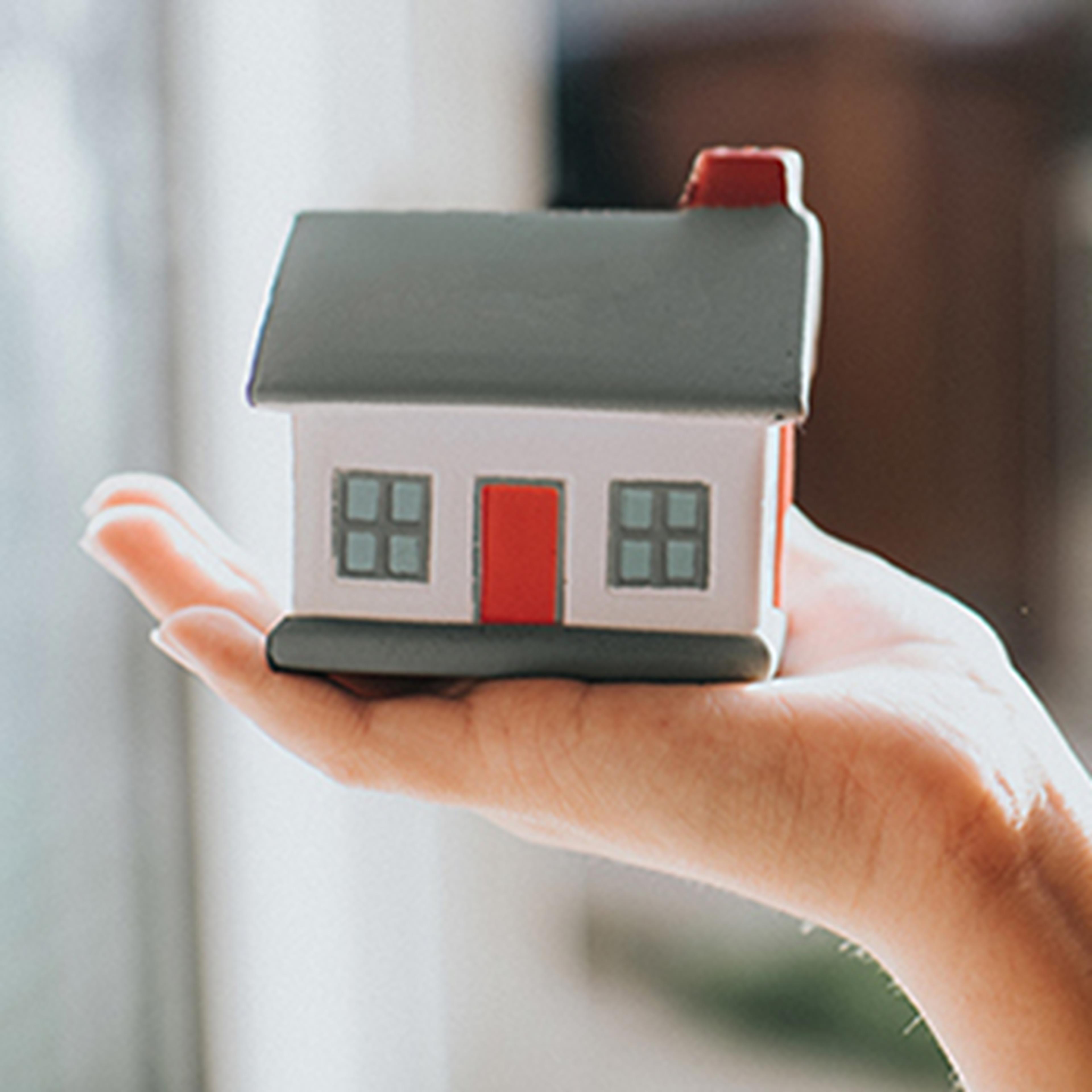 Hand holding small model home decoration