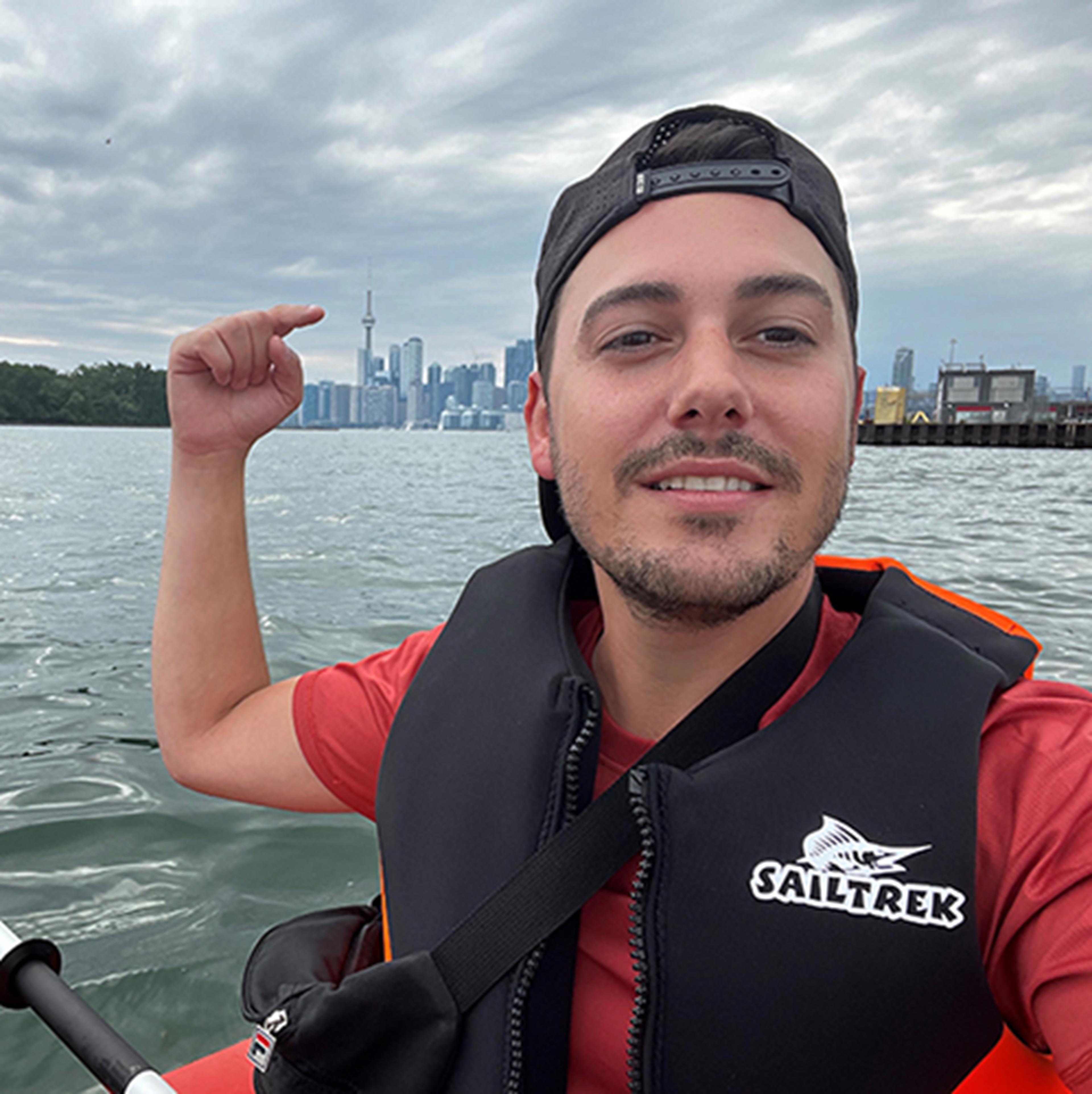 Picture of Jake out in Lake Toronto pointing to the CN Tower