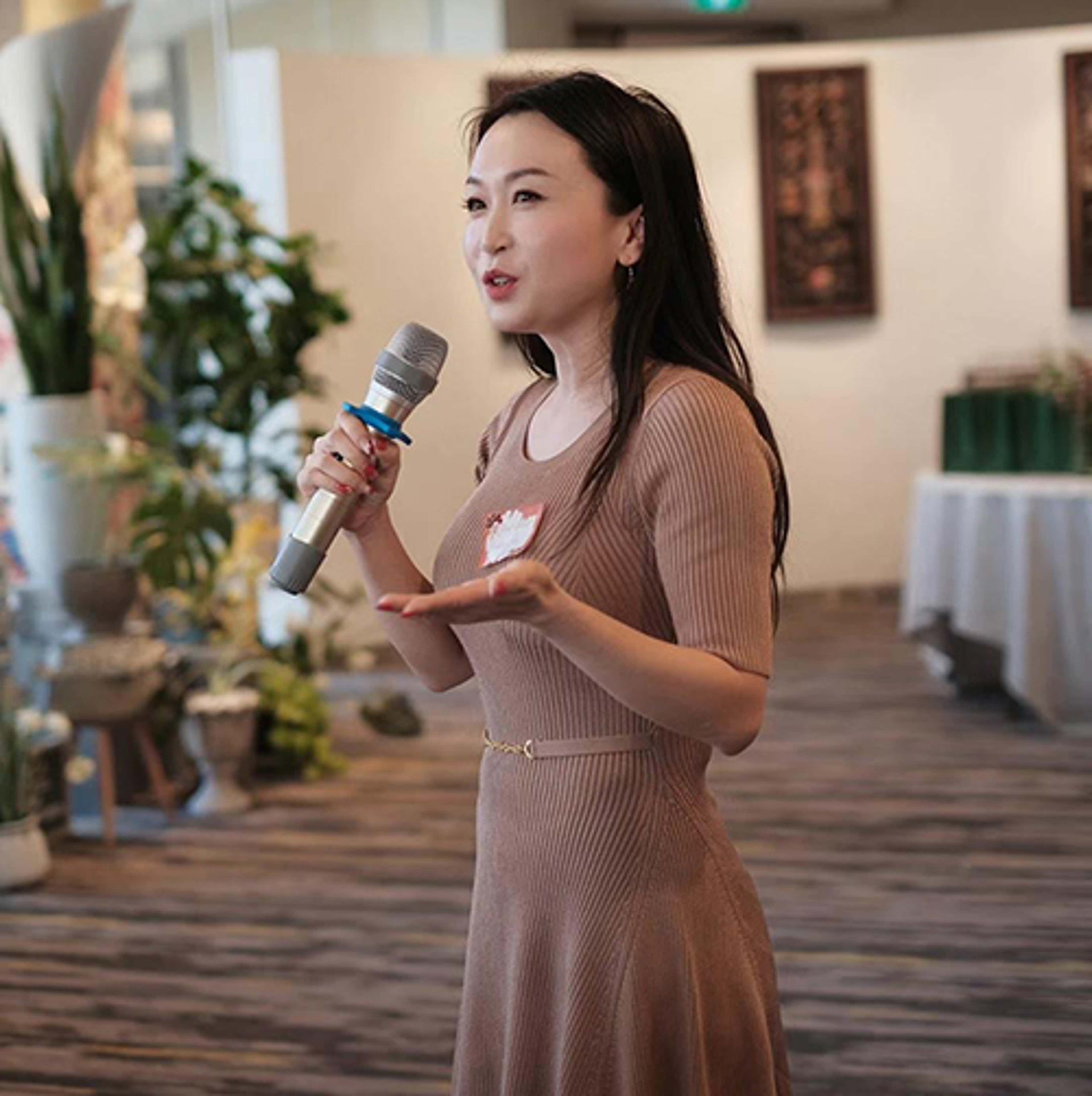 Jennifer standing with microphone speaking