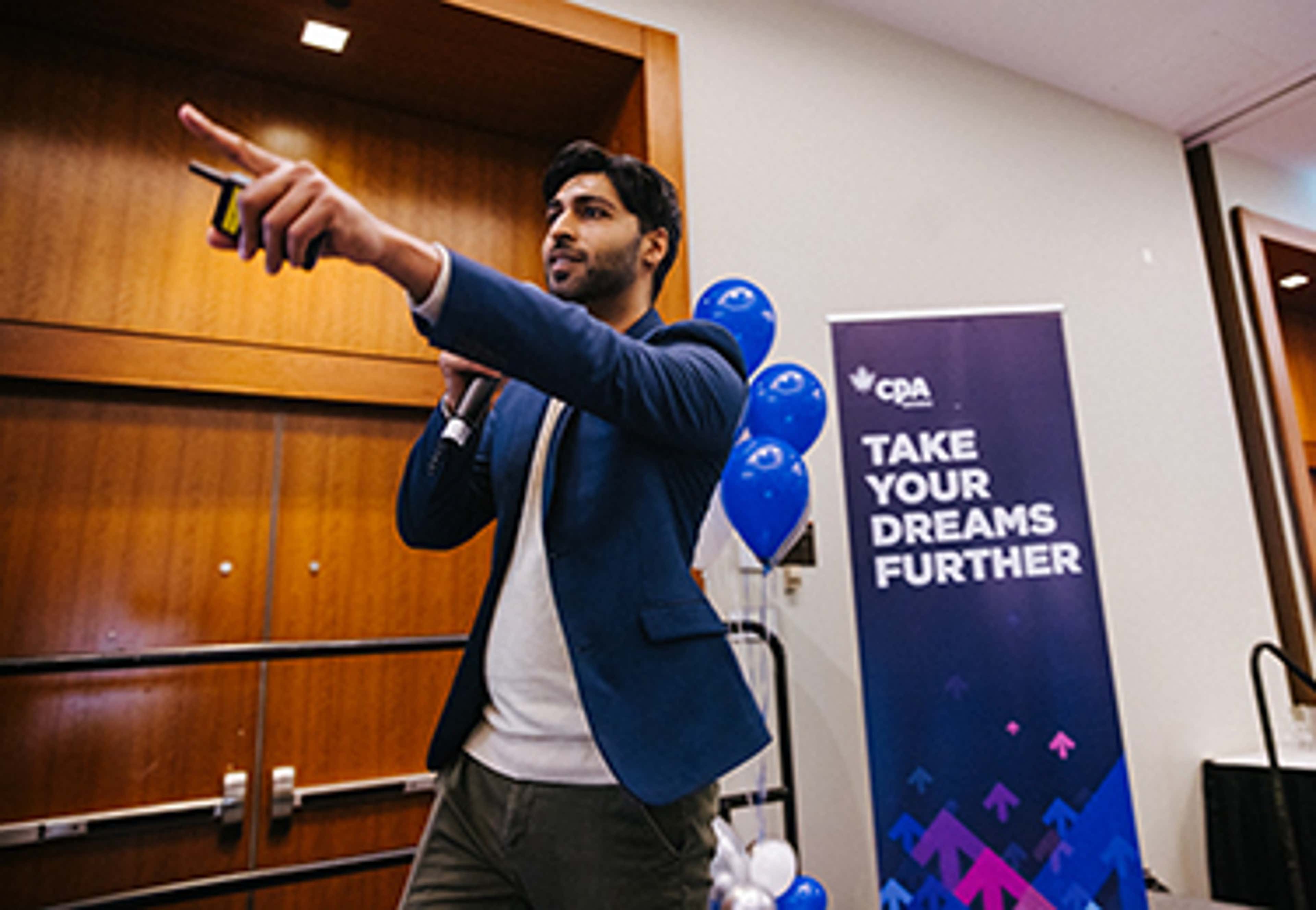 Speaker on stage pointing finger and holding mic