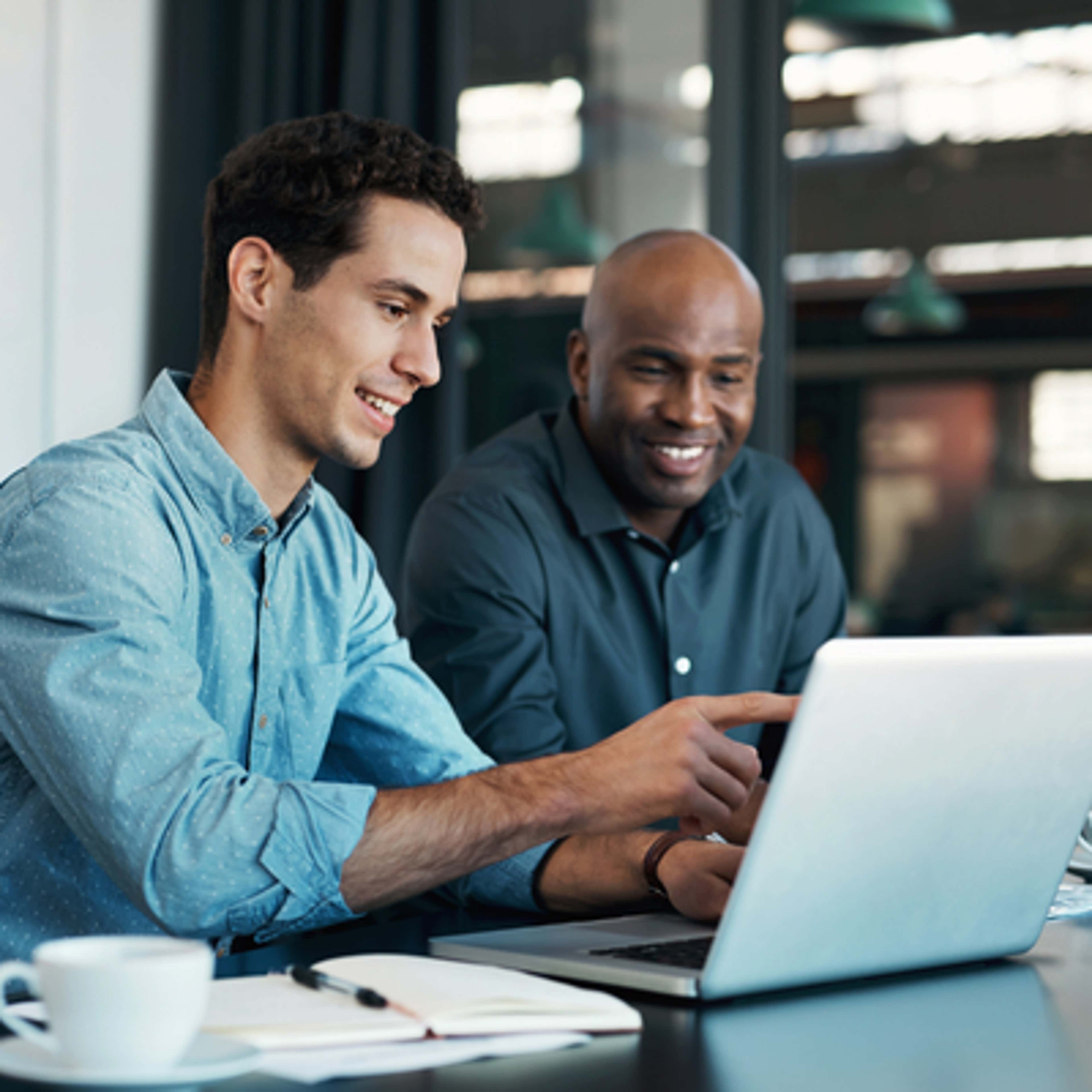 two man looking at laptop