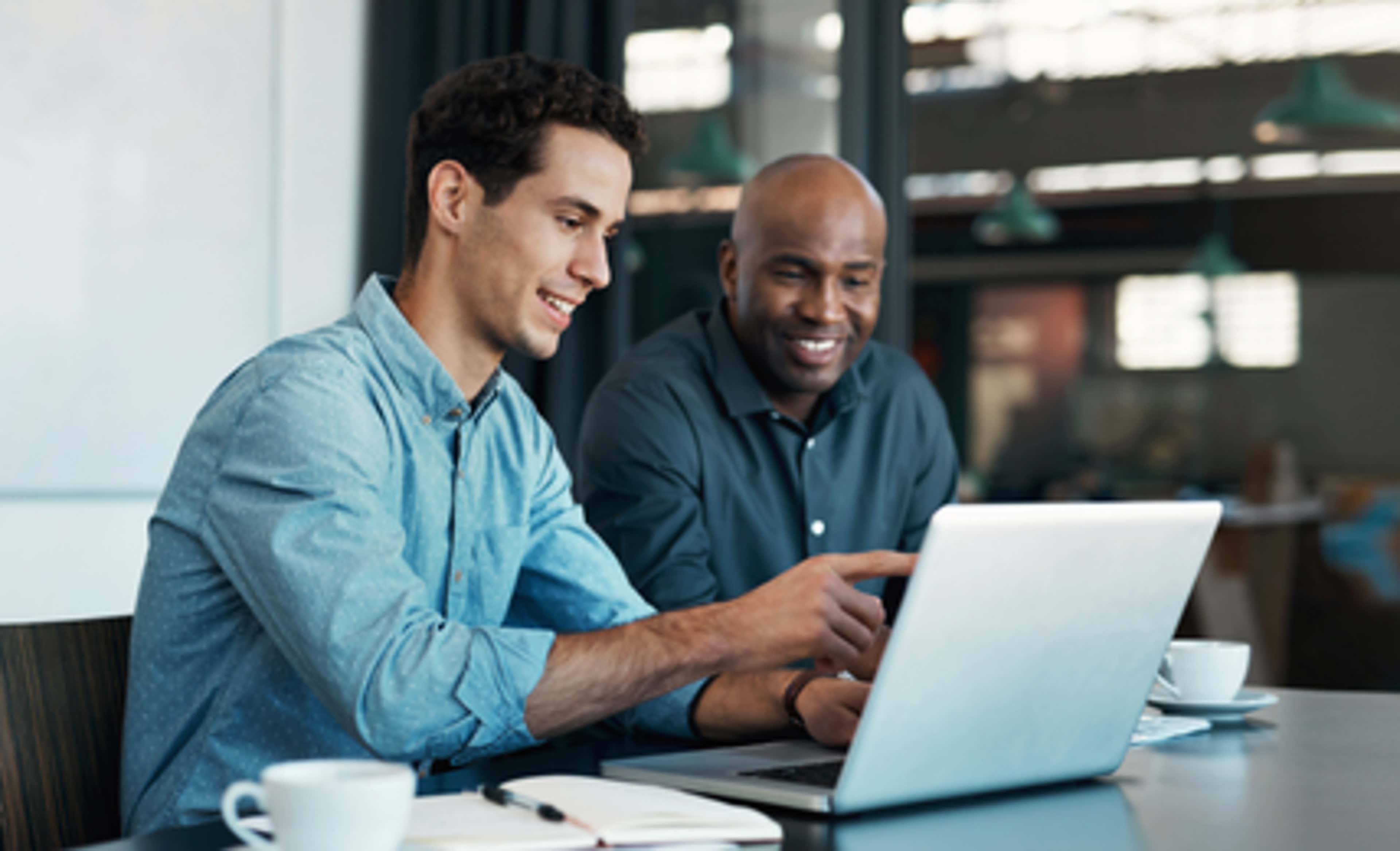 two man looking at laptop