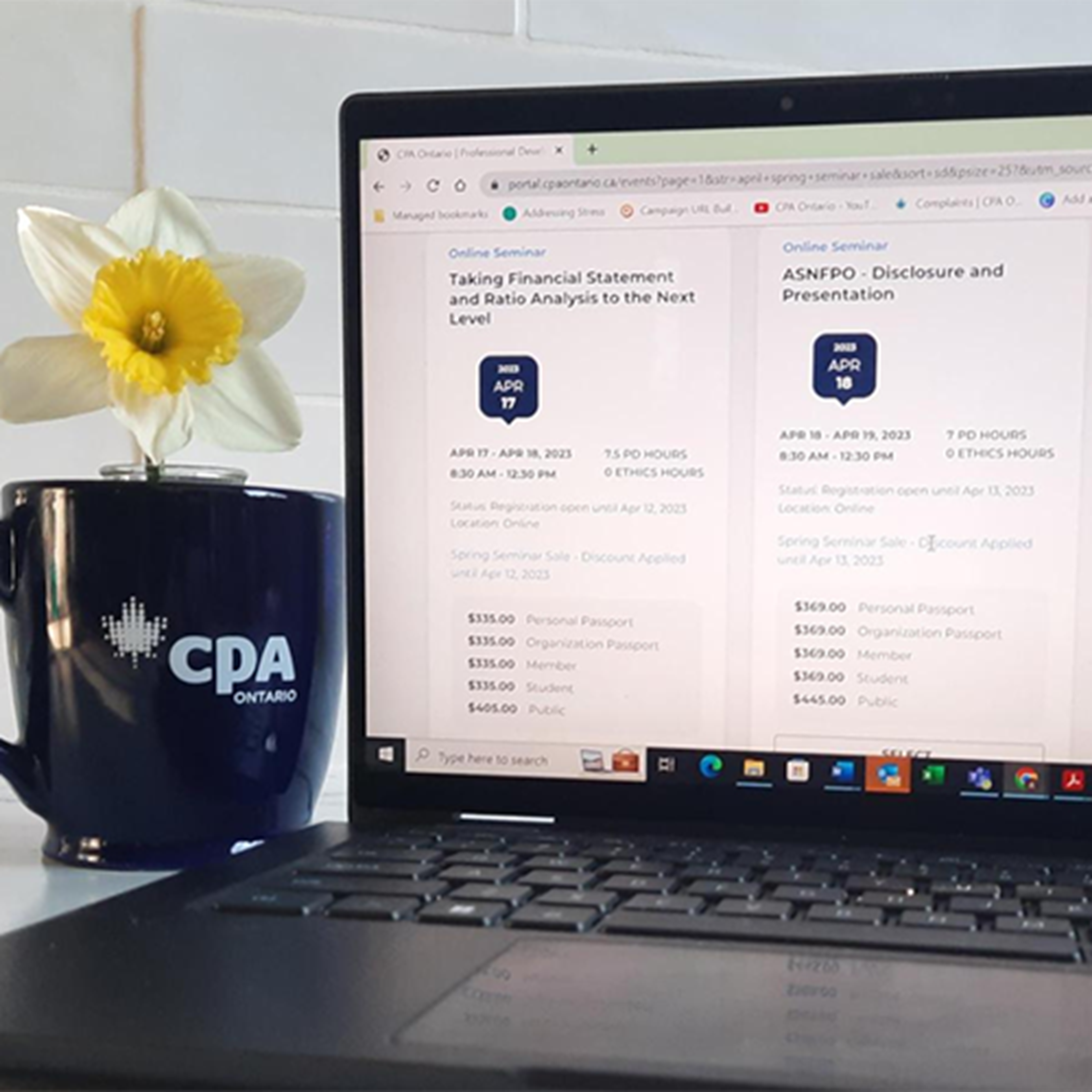 Picture of laptop with course website and daffodil in a CPA Ontario mug beside it