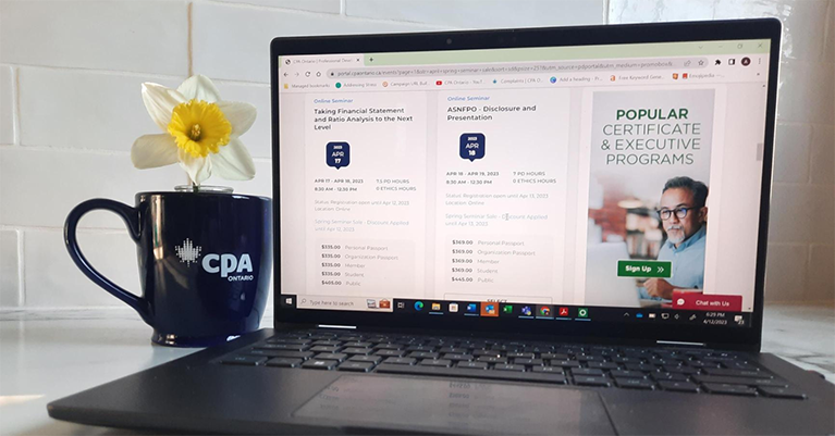 View of laptop with CPA mug with a flower in it