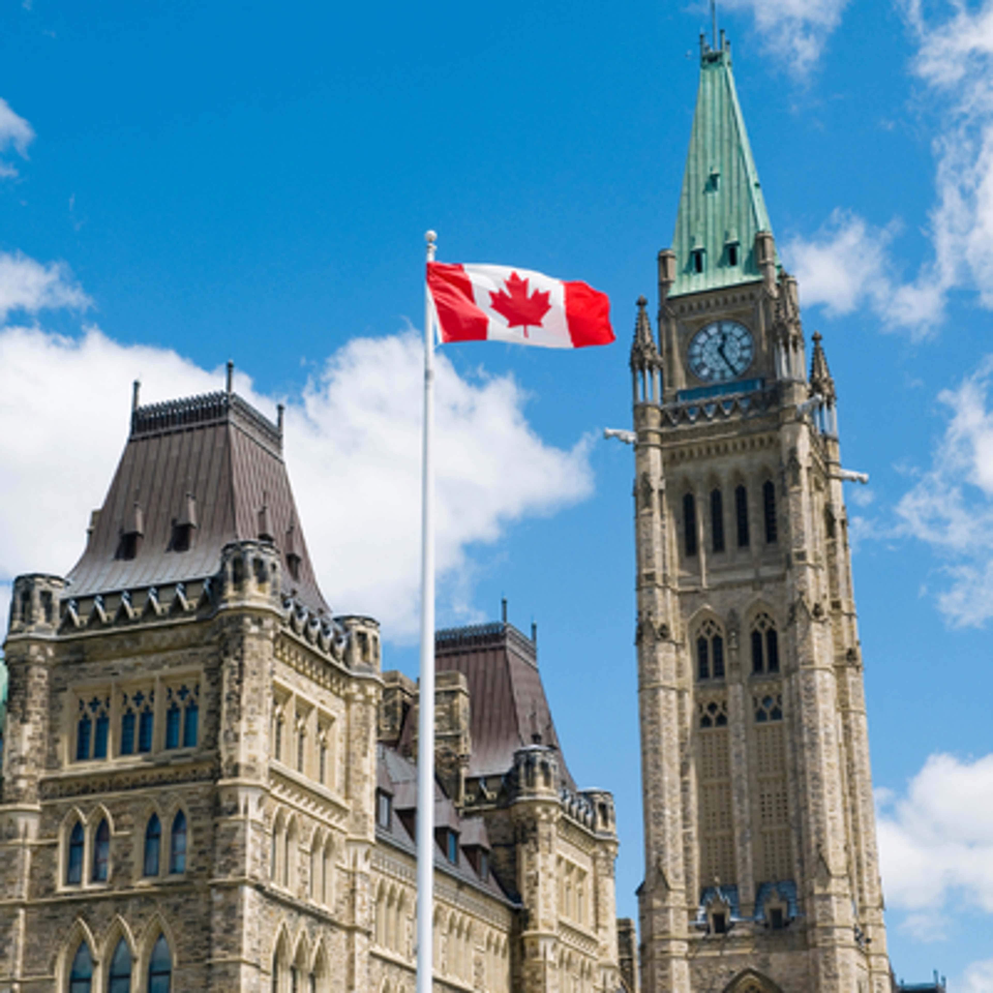 A Canadian flag waves proudly in front of a building