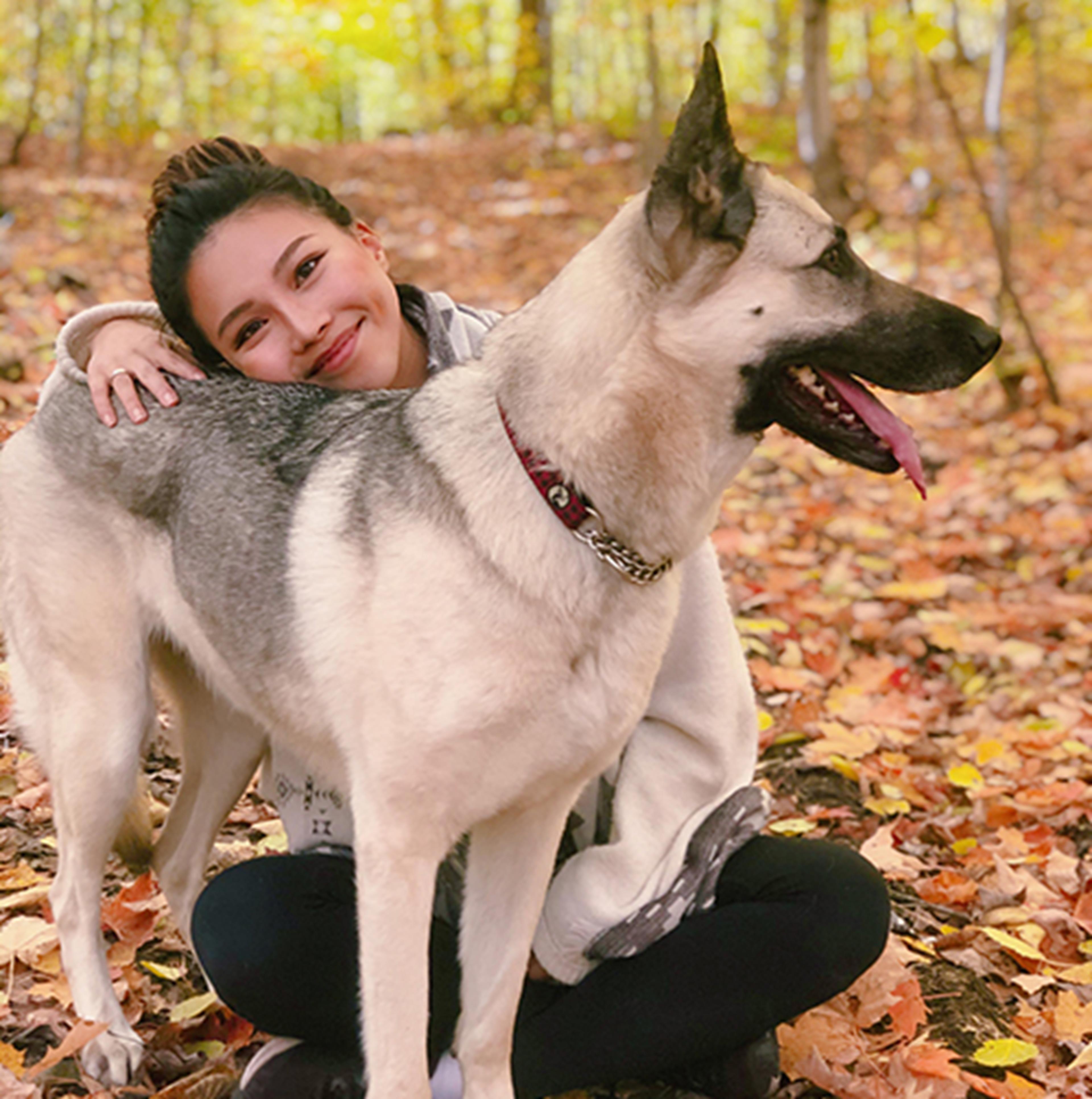 Della Wang in a forest with a German shepherd dog