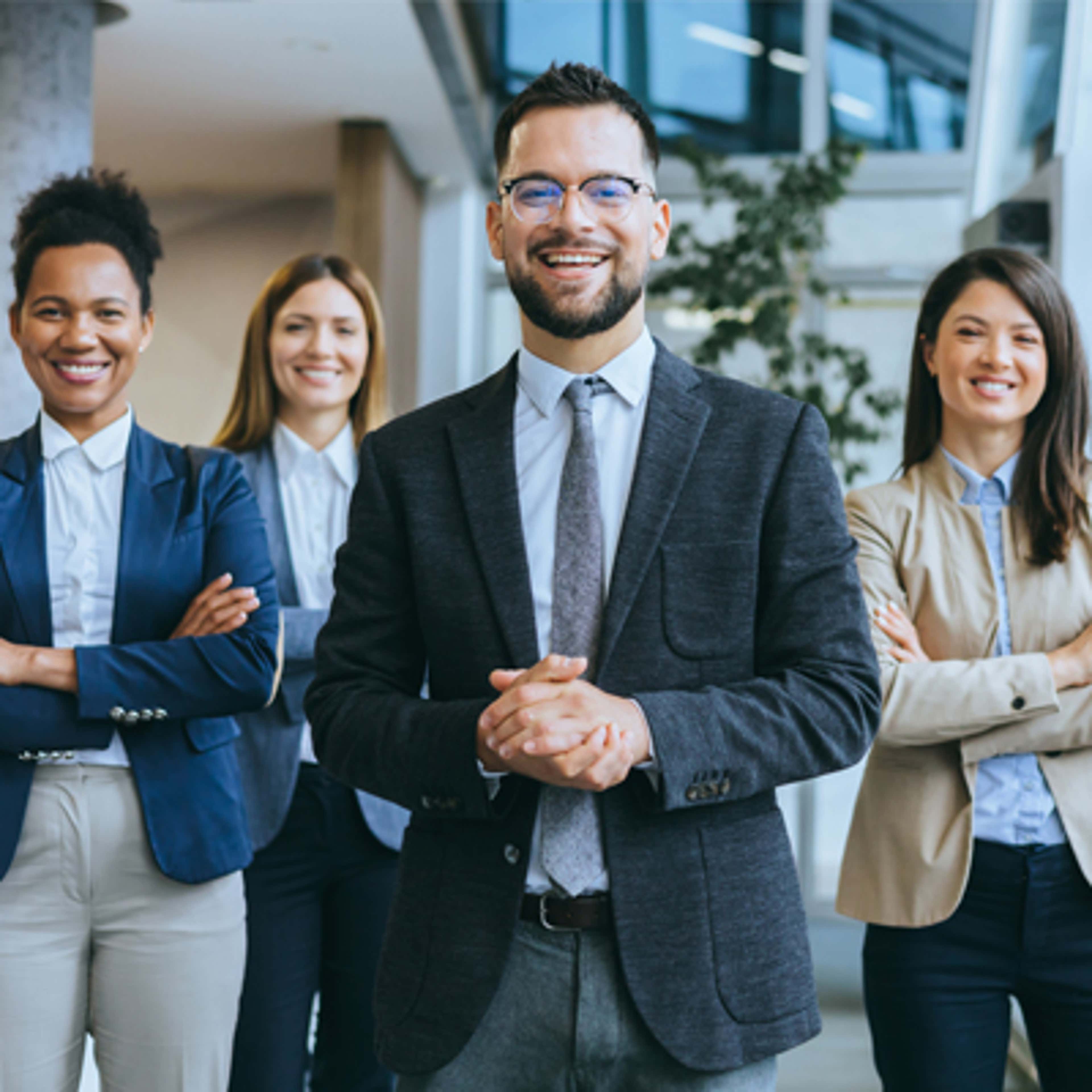 Four people smiling with their arms crossed