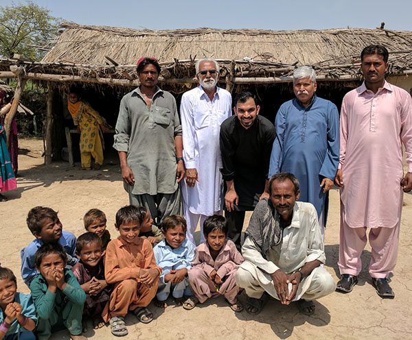 Fahad and the local Shift team standing with a group of children they met while visiting the first project in Gujranwala