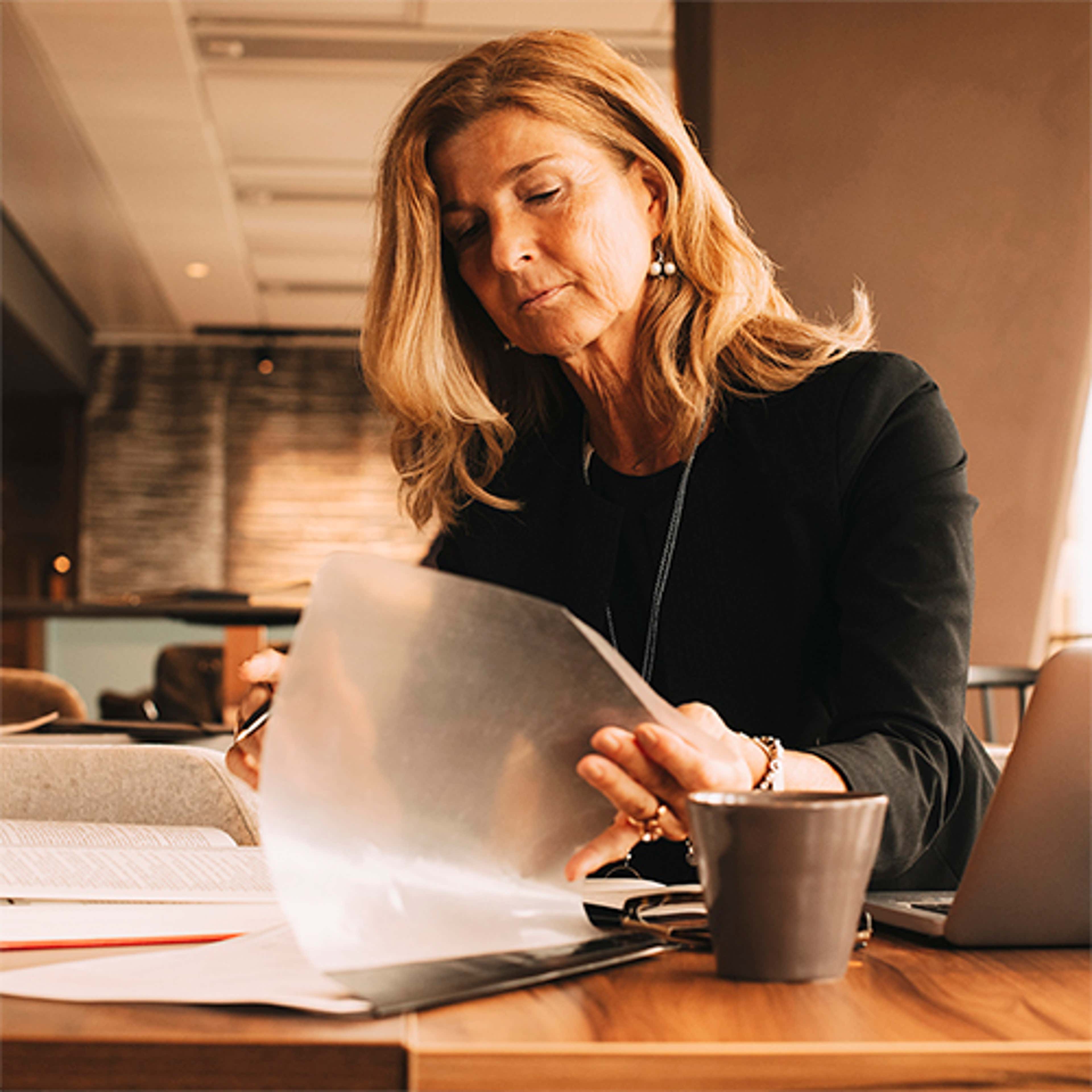 Woman at cafe looking at reports