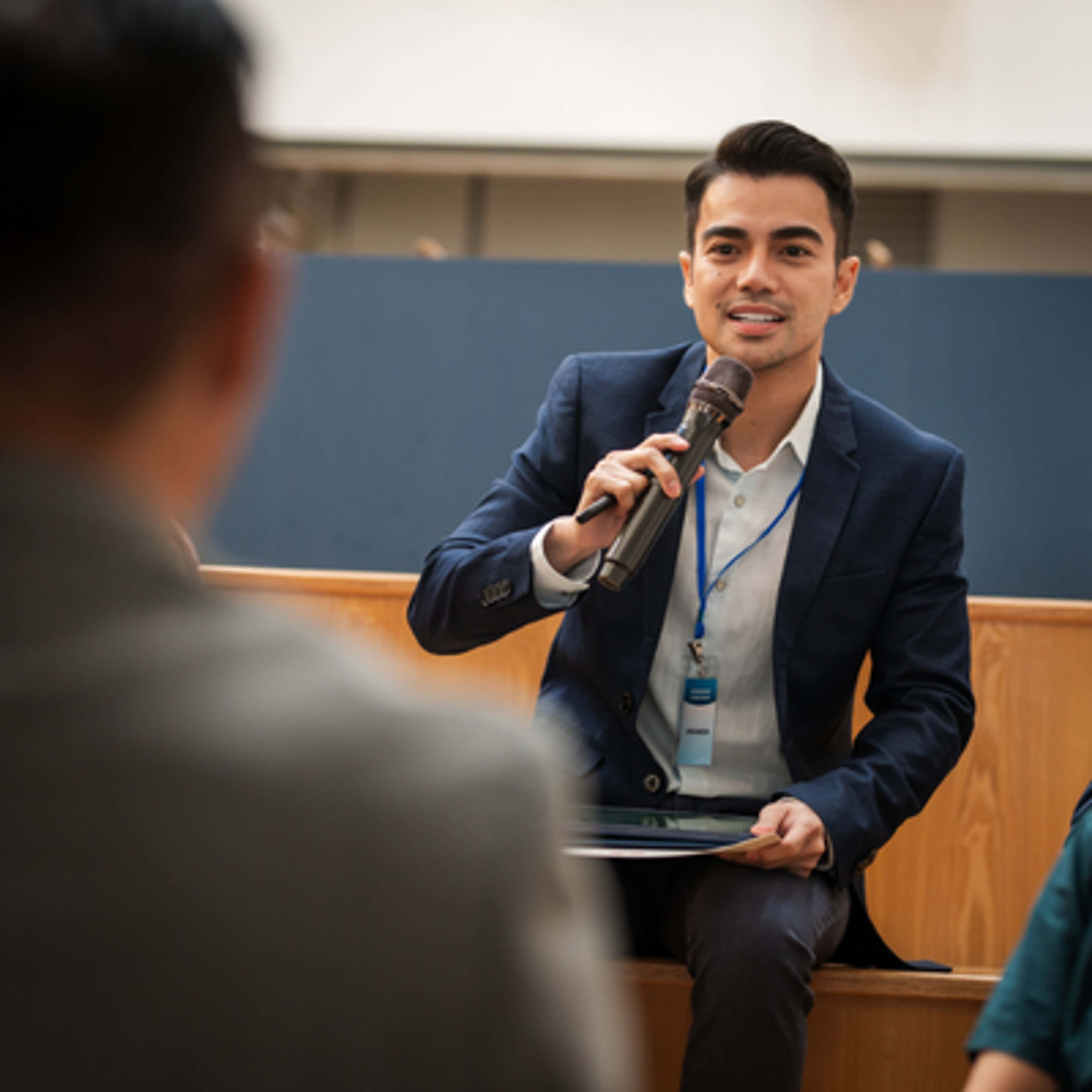 Man holding a mic presenting