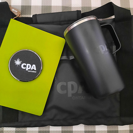 CPA Ontario black duffle bag, black tower mug, black circular wireless charger and green notebook