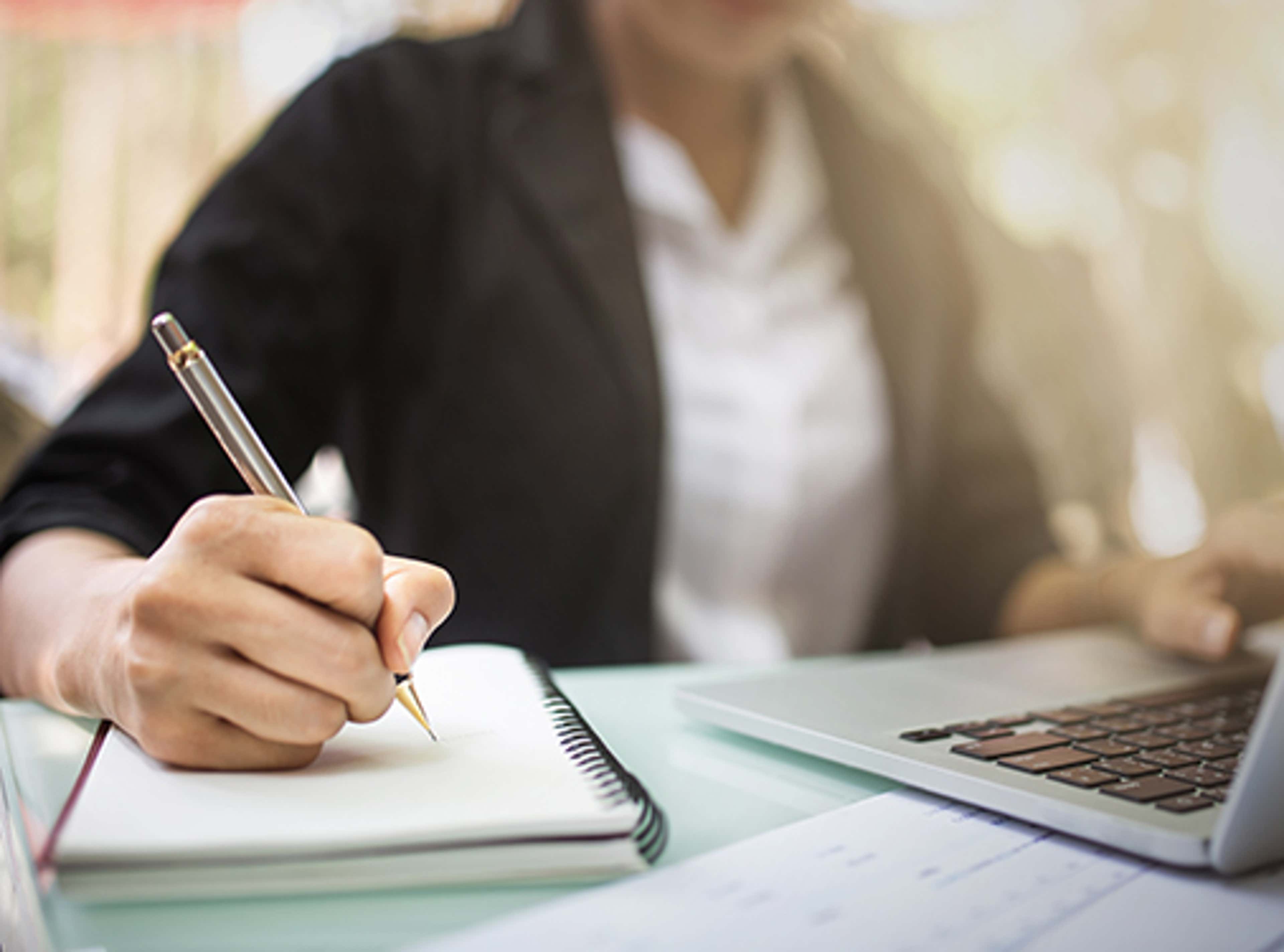 Person writing with pen on paper