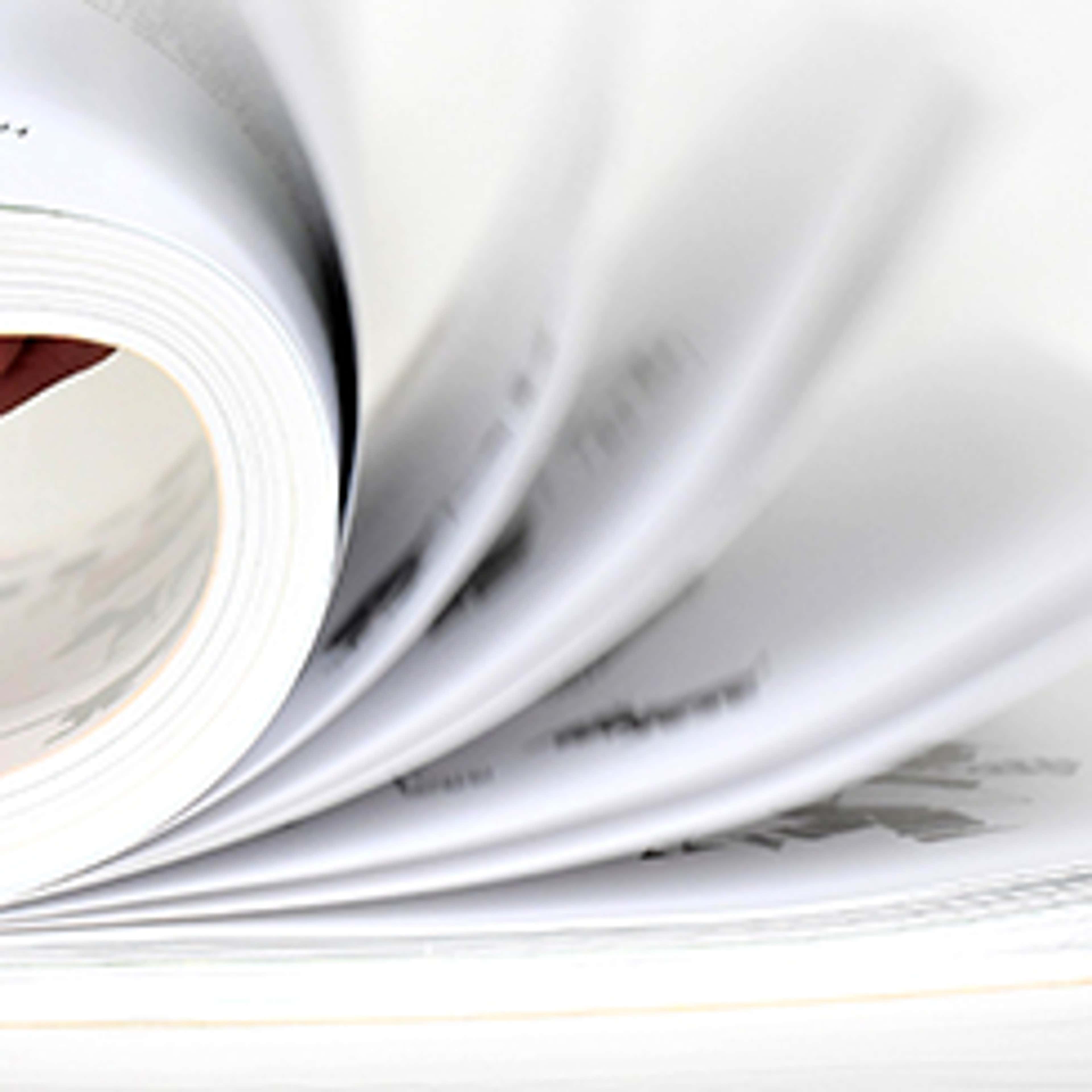 Pages flipping in a book against a white background