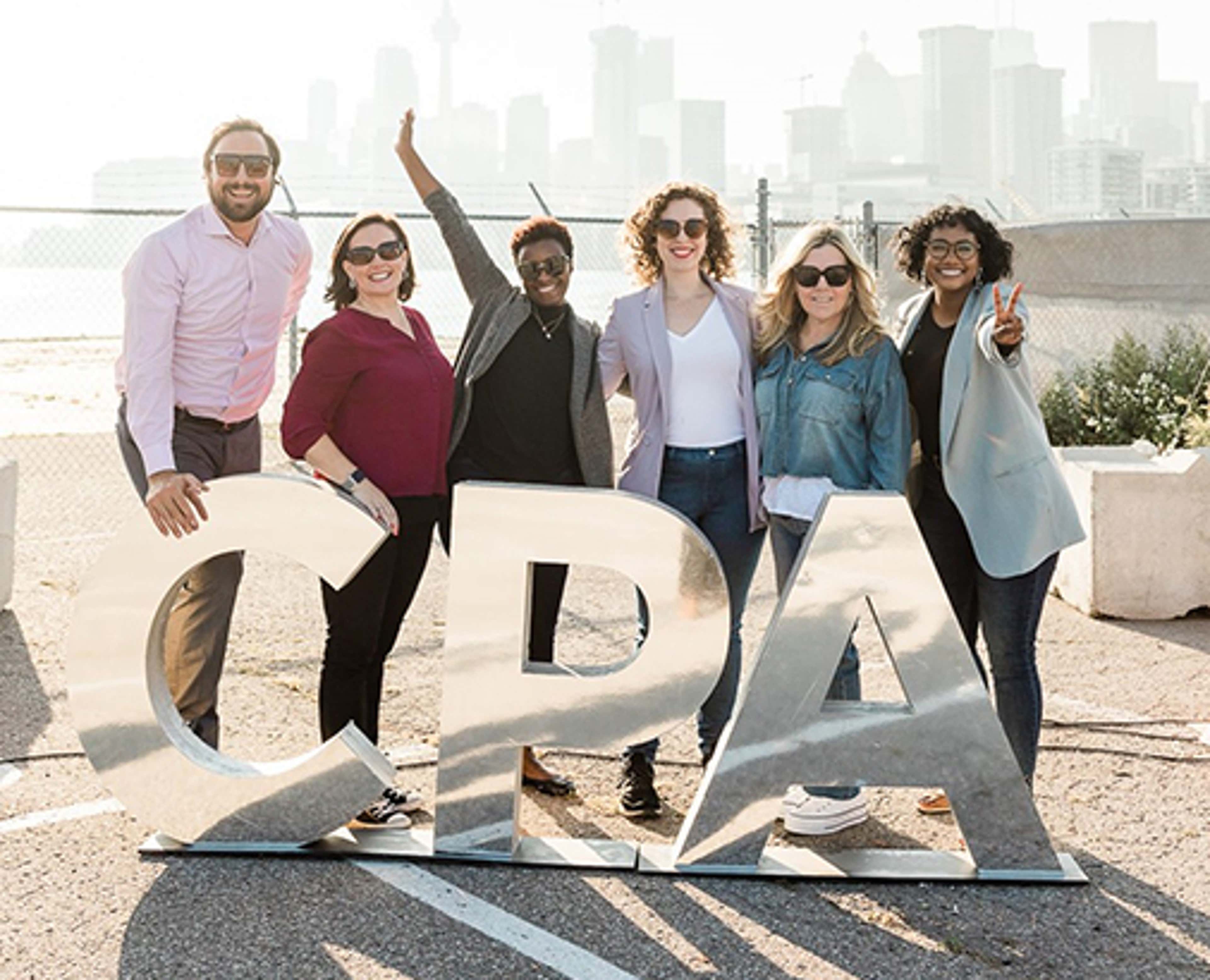 Six people outside behind a CPA sign