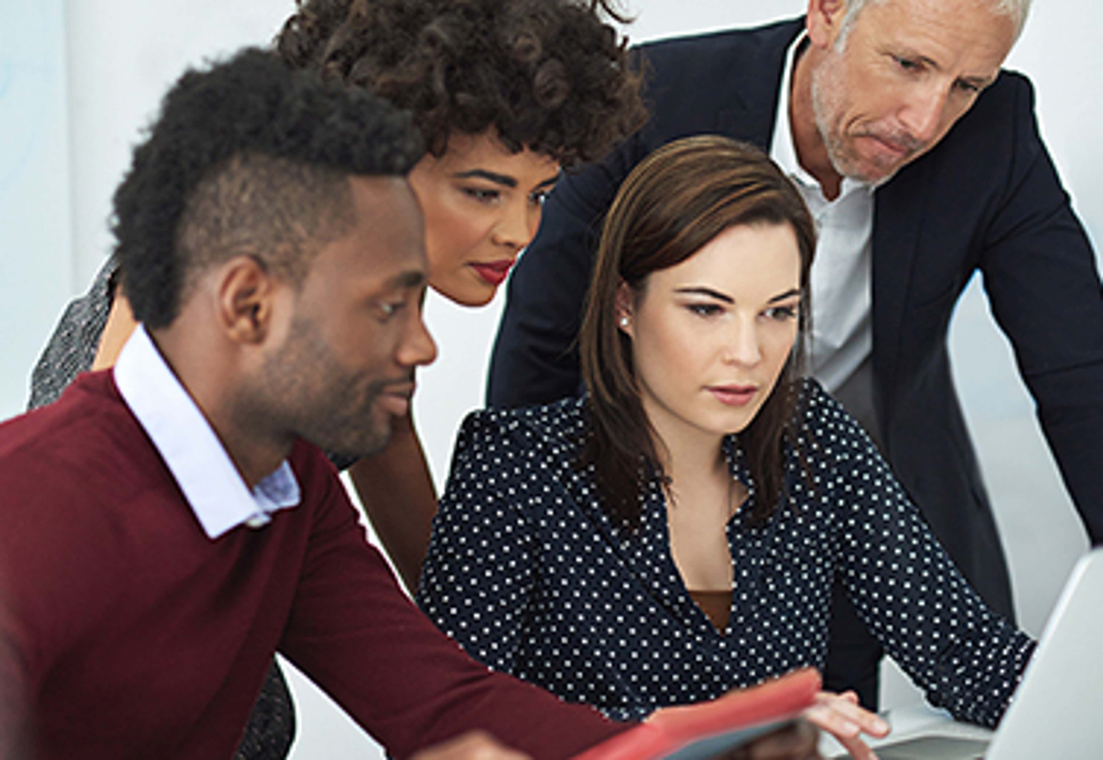 Four people looking at a laptop