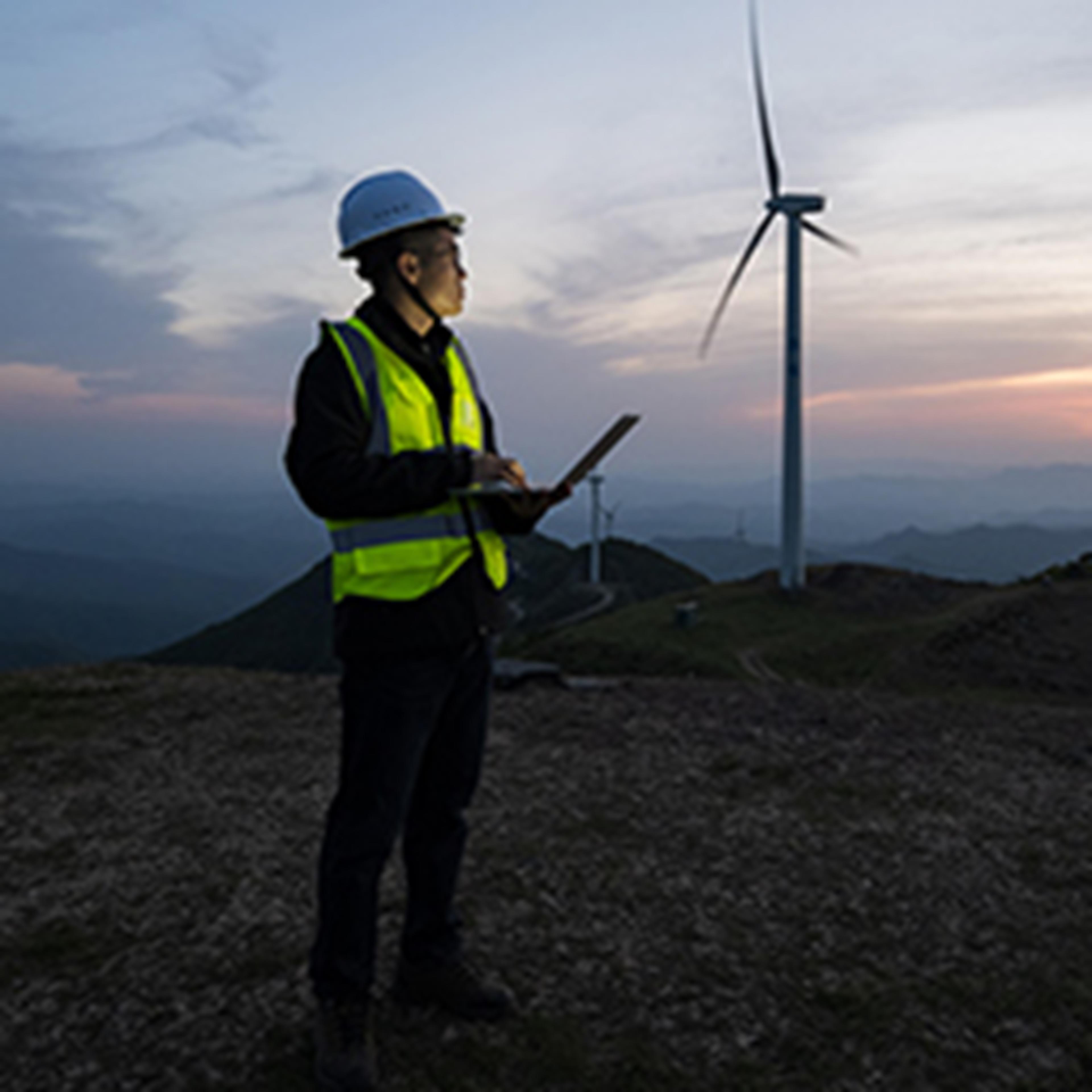 A man standing in front of wind turbines